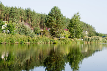 River house with reflections and blue sky near the forest