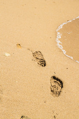 Footprints in the sand beach near the sea