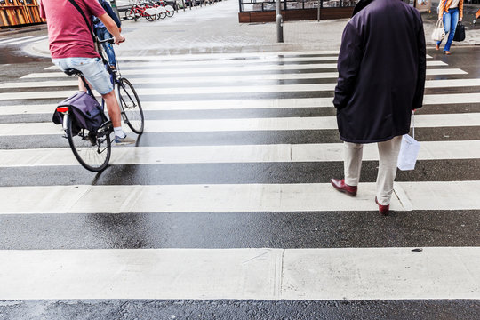 Menschen &uuml;berqueren am Zebrastreifen die Stra&szlig;e
