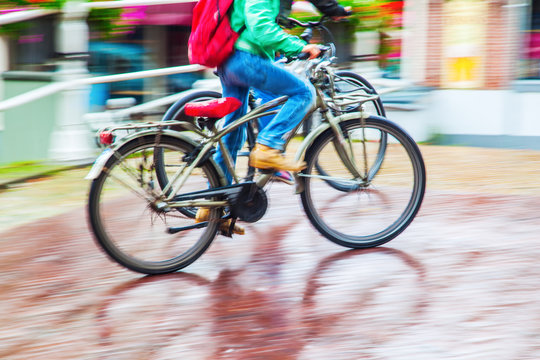 Radfahrer bei Regenwetter in Bewegungsunschärfe