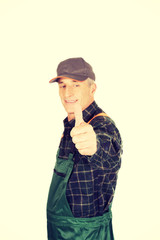 Mature gardener in uniform with thumbs up