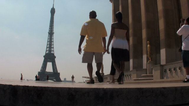 Tourists walk towards the Eiffel Tower in paris.