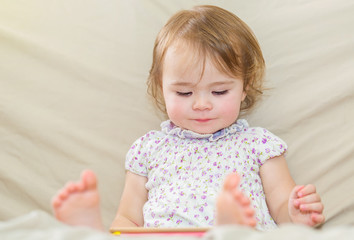 Happy toddler girl using a tablet computer