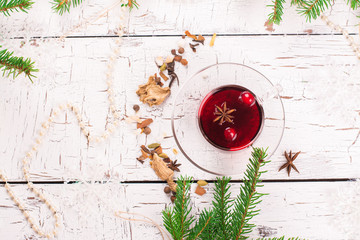 Red berry tea with cranberry and spices on white wooden table. Xmas or new year decorated background. Selective focus