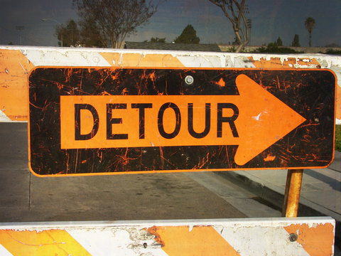 aged and worn vintage photo of detour sign with arrow