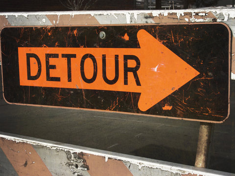 aged and worn vintage photo of detour sign with arrow