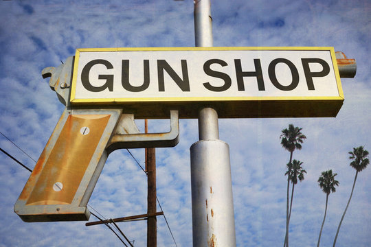 aged and worn vintage photo of gun shop sign
