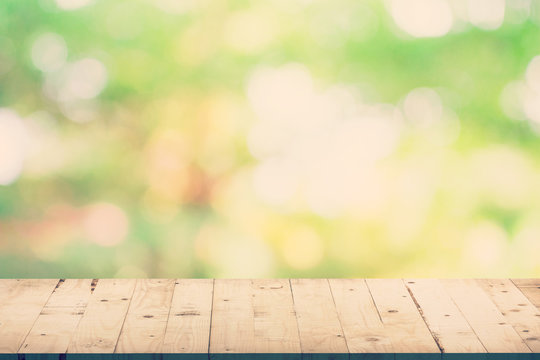 Green leaf bokeh blur and wood table for natural background