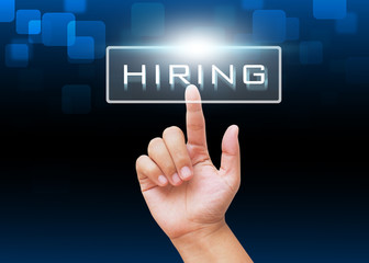 Hand pressing HIRING button to find new job on technology background