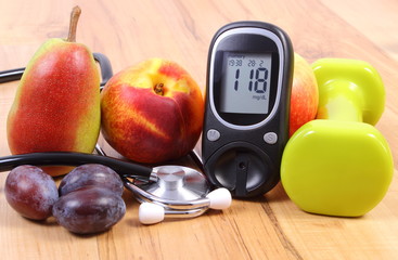 Glucose meter with medical stethoscope, fruits and dumbbells for using in fitness
