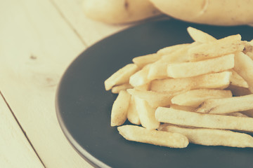 french fries on wood background - soft focus with vintage film f
