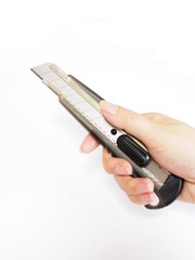 カッターナイフを持つ女性の手