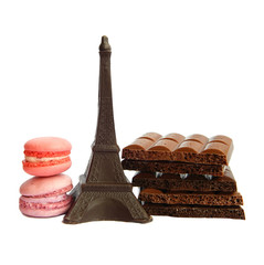 Chocolate Eiffel Tower, two macarons and broken milk and dark chocolate bars on white background