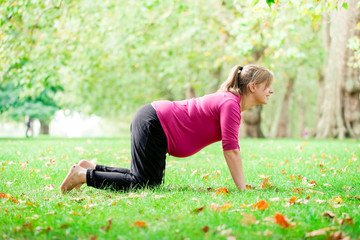 Pregnant woman playing yoga at the Hyde Park, London