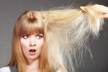 Blonde woman with her damaged dry hair. © Voyagerix