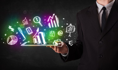 Young person holding tablet with graph and chart symbols