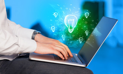Close up of hand with laptop and  idea bulb