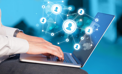 Close up of hand with laptop and social media icons