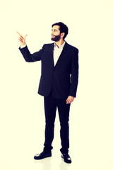 Happy businessman points his finger up.