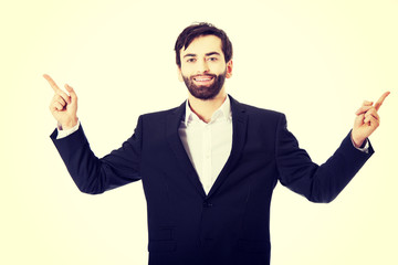 Happy businessman points his finger up.