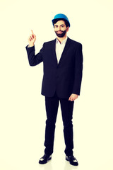 Engineer in protective helmet pointing up.