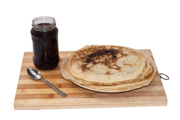 Pile of pancakes with jar of strawberry jam
