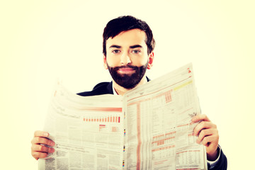 Young man reading newspaper in the office.