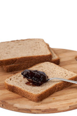 Strawberry jam on the metal spoon over bread