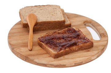 Wooden spoon and strawberry jam on the bread