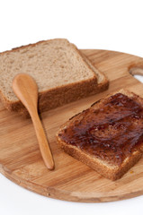 Wooden spoon and strawberry jam on the bread