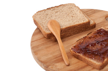 Wooden spoon and strawberry jam on the bread