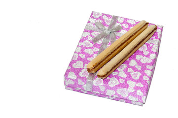 Chocolate wafers on the pink gift box with bow