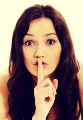 Naklejka premium Young woman with finger on lips.