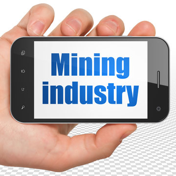 Industry concept: Hand Holding Smartphone with Mining Industry
