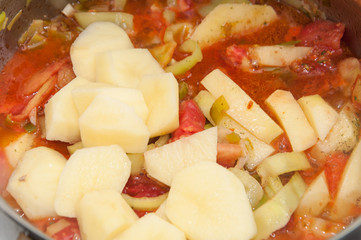 Cooking tomato and potato stew in the bowl