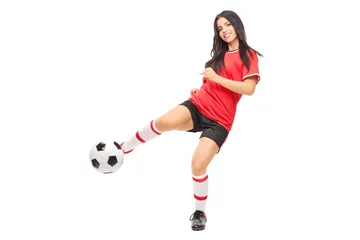Foto op Canvas Cheerful female soccer player shooting a ball © Ljupco Smokovski