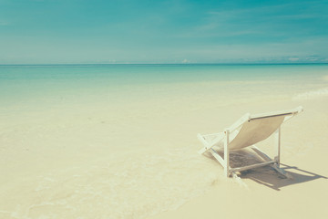 beach chair on beach with blue sky - soft focus with film filter
