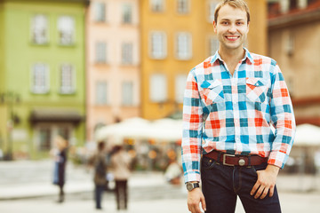 Fototapeta premium Enjoy tourism concept. Smiling young handsome man in trendy shirt