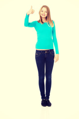 Fototapeta premium Happy female student showing thumbs up
