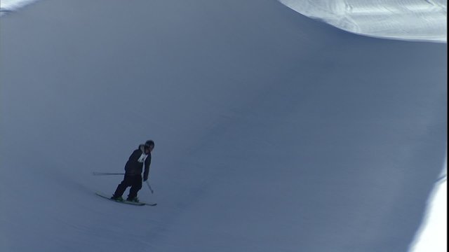 Skier on half pipe, does nice flip, & wipes out
