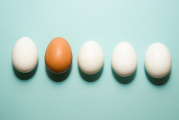 Chicken eggs of different colors on blue surfase