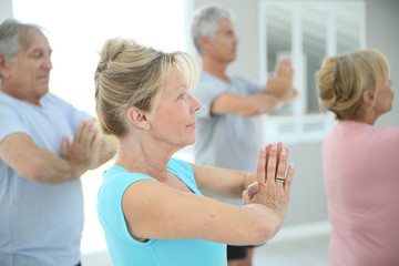 Fototapeta na wymiar Group of senior people doing fitness exercises in gym