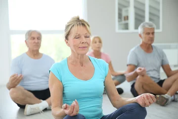 Foto op Plexiglas Group of senior people doing yoga exercises © goodluz