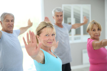 Senior people stretching out in fitness room - obrazy, fototapety, plakaty