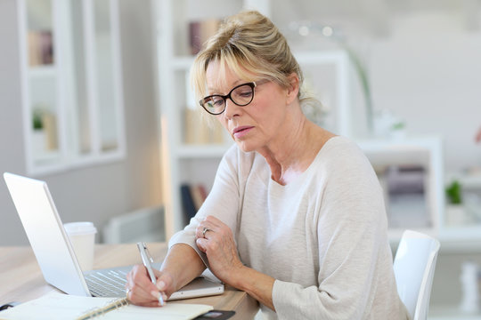 Portrait Of Senior Woman Working On Laptop Computer