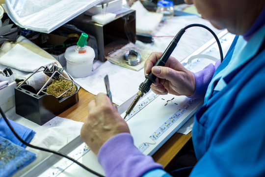 Manufacturing. Worker Soldering Circuit Board