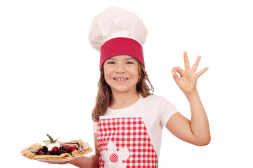 happy little girl cook with crepes and ok hand sign