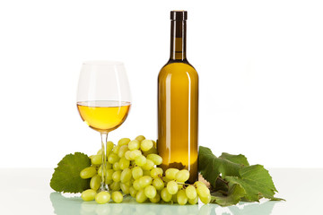 Weißwein im Glas und in der Flasche mit Weintrauben