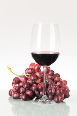 Rote Weintrauben und Rotwein im Weinglas