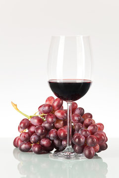 Rote Weintrauben und Rotwein im Weinglas